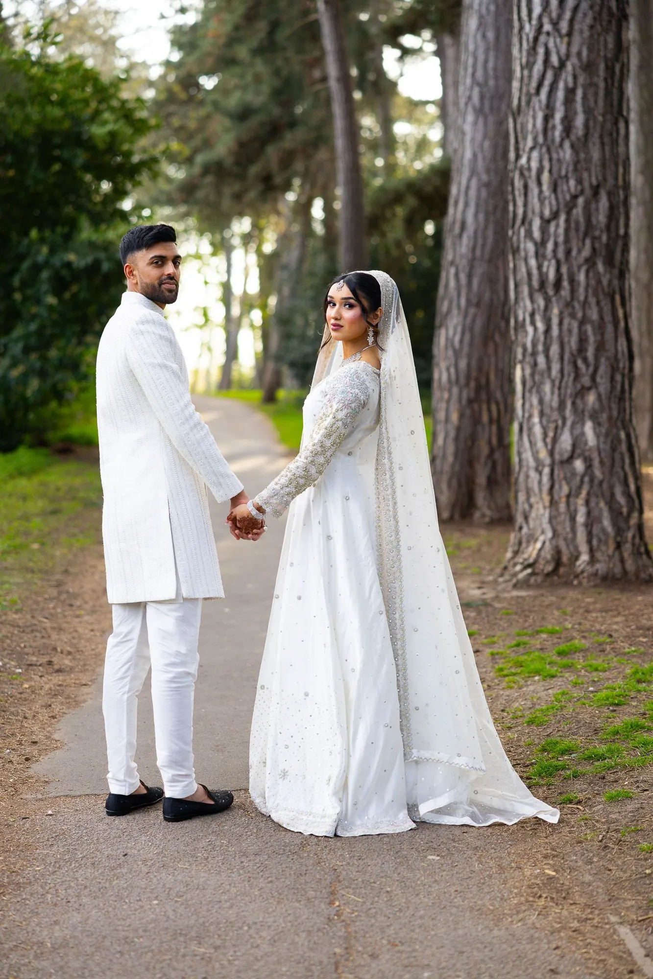 Romantic portrait of a bride and groom beneath tall trees